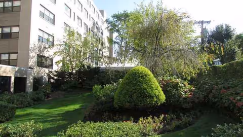 Exterior view of Clove Lakes Health Care and Rehab Center with a landscaped courtyard.