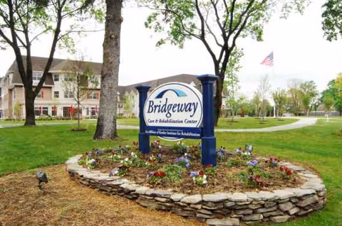 Exterior view of Bridgeway Care and Rehabilitation Center sign with landscaped front yard