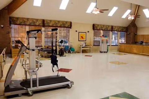 Spacious rehab gym area with equipment in a senior living facility.