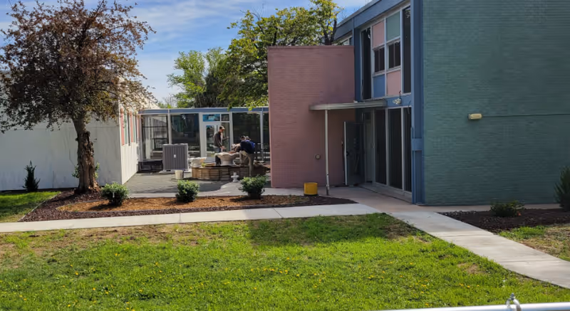 Outdoor courtyard at Solange at Citadel Assisted Living with residents near patio seating.