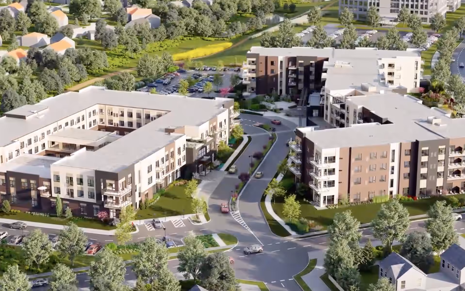 Aerial rendering of Ovation Heartwood Preserve showing multiple low-rise residential buildings, roads, parking and landscaped grounds.