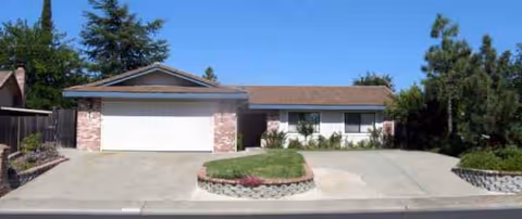 Single-story facility with a garage door, driveway, and manicured front landscaping.