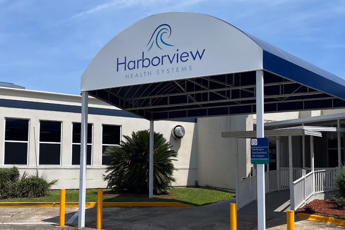 Covered entrance canopy reading 'Harborview Health Systems' in front of a low building with a walkway and landscaping.