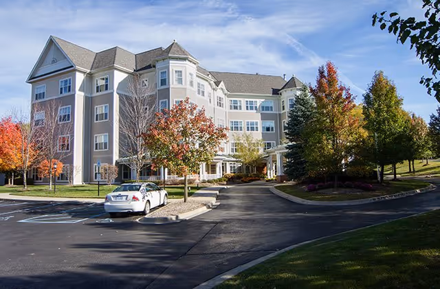 Exterior view of Atria Park of Ann Arbor, a multi-story senior living building with a driveway.