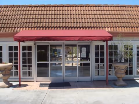 Front entrance of Newport Subacute Healthcare Center with glass doors and a red canopy.