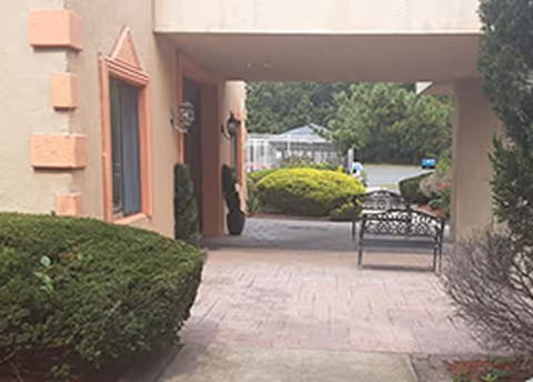 Pathway leading to the entrance of the Manahawkin Health and Rehabilitation Center, surrounded by greenery.
