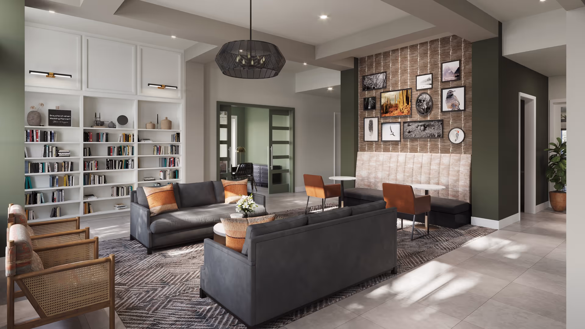 Bright, modern communal lounge with gray sofas, armchairs, bookshelves, and a framed gallery wall.