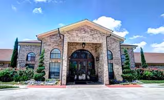 Front exterior of Tuscany Village Skilled Nursing and Rehabilitation building with arched entry.