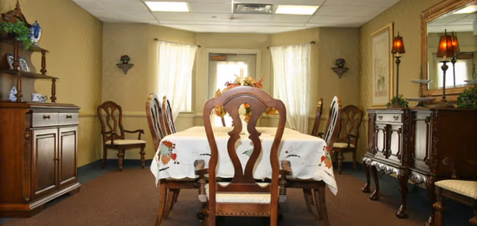 Formal dining room with a wooden table and chairs, sideboards, and decorative lamps.
