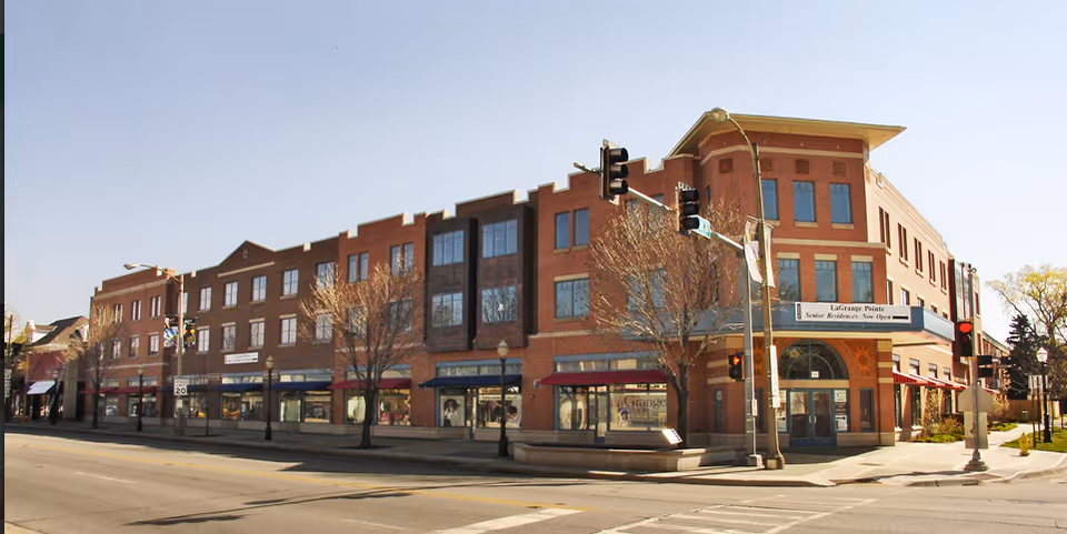 Brick, multi-tenant building on a corner with storefronts and LaGrange Pointe signage.