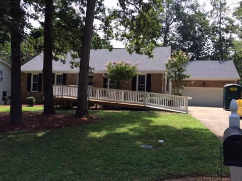 Single-story brick senior living facility with a ramp and well-kept lawn