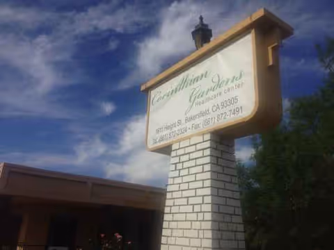Exterior view of a senior care facility sign on a brick pillar at the entrance.