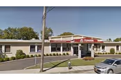 One-story Oceanside Nursing Center exterior with entrance, sign, parking, and landscaping.