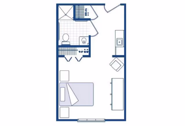 Floor plan of a senior living studio apartment featuring a combined bedroom and living area with a bed, nightstand, chair, and a long table or counter. The layout includes a small kitchen area with a sink and a bathroom with a shower, toilet, and sink.