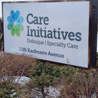 Outdoor sign reading "Care Initiatives Dubuque | Specialty Care, 2935 Kaufmann Avenue" with a logo and landscaping in front.