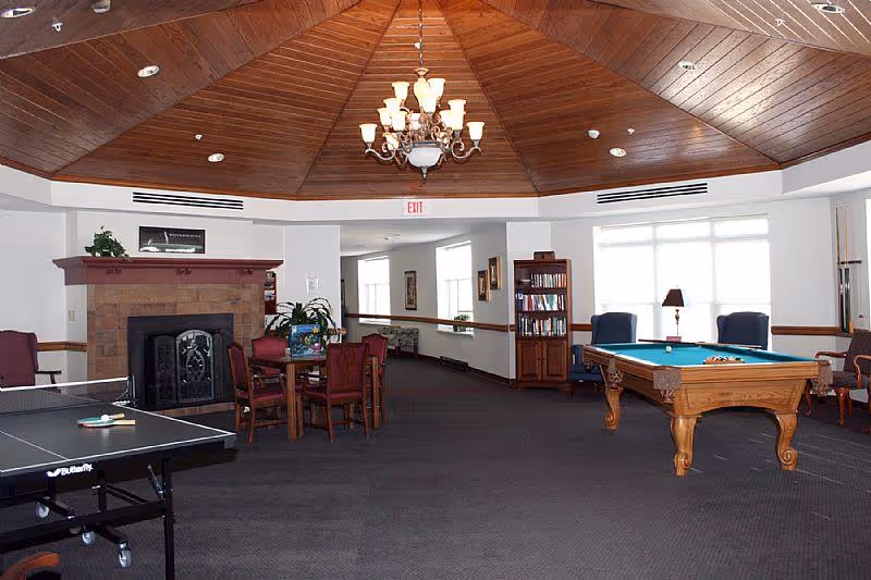 Spacious common room with a wooden-domed ceiling, fireplace, pool table, ping-pong table and seating areas.