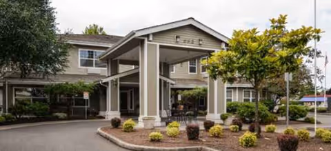 Exterior view of Brookdale River Road with a porte-cochère entrance and landscaped surroundings.