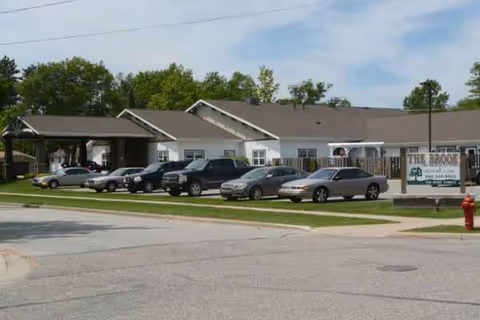 Exterior front of The Brook of Grayling with multiple parked cars.