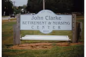 Outdoor sign for John Clarke Retirement & Nursing Center with the address number 600, situated on a grassy area near a street.