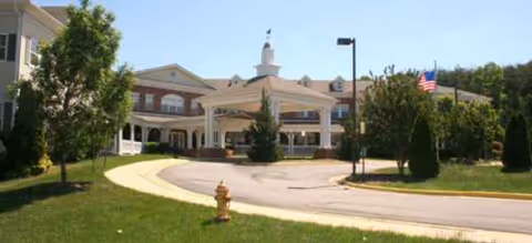 Exterior view of Brookdale Lake Ridge with entrance canopy, curved drive, and trees.