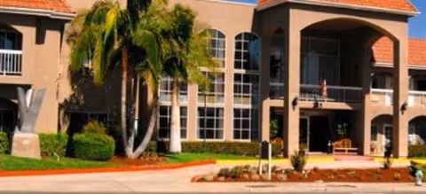 Exterior view of Brookdale Brea facility with palm trees and arched entrance