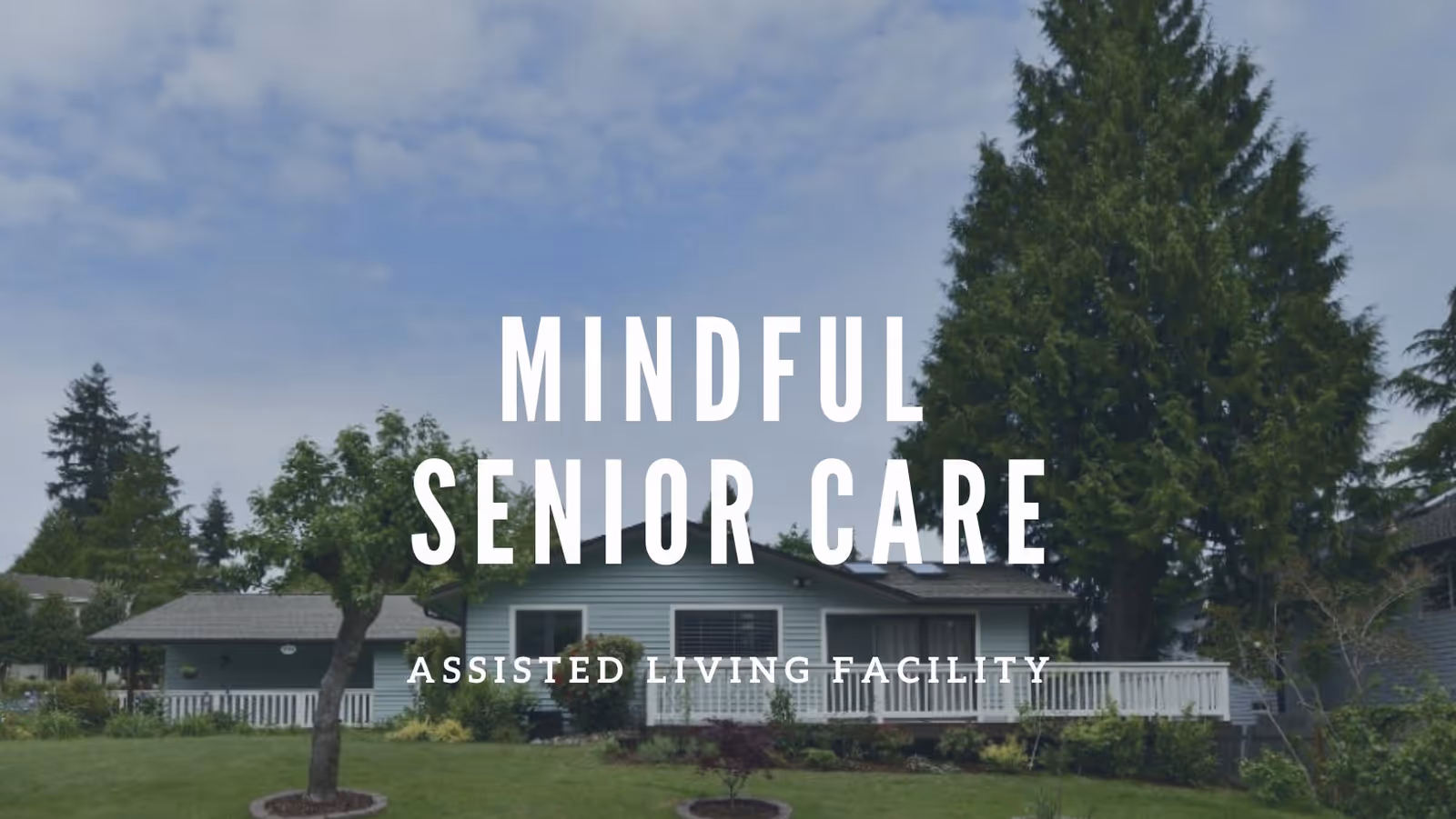 Exterior view of a single-story assisted living facility building surrounded by trees and greenery under a partly cloudy sky.