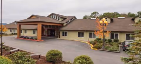 Single-story senior living facility with a covered entrance and surrounding landscaping.