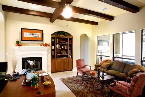 Interior living room with fireplace, built-in cabinet, and comfortable seating at Longhorn Village.