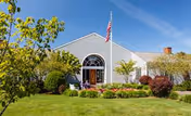 Front view of Broad Reach Healthcare building with landscaped lawn, trees, and American flag.