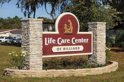 Stone pillars frame a maroon Life Care Center of Hilliard sign in a landscaped outdoor area.