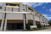 Exterior view of West Park Rehabilitation and Nursing Center, a beige building with entrance canopy.