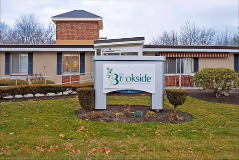 The Brookside Rehabilitation and Healthcare Center exterior with sign and landscaped front yard.
