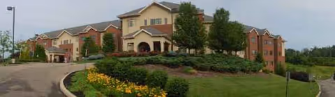 The Wellington at North Bend Crossing exterior shows a multi-building senior living campus with landscaped grounds.