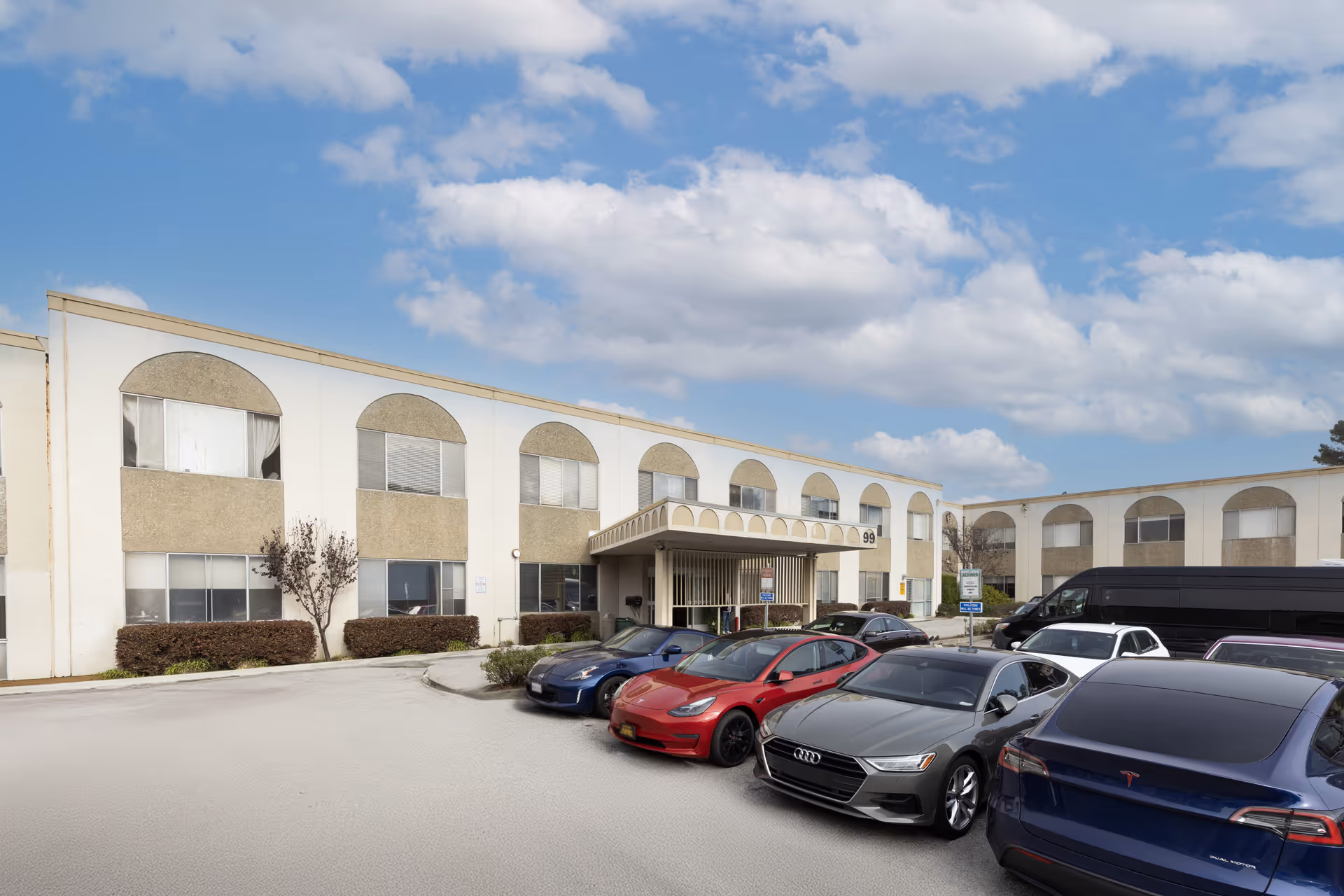 Exterior view of Golden Sonora Care Center with arched windows and a row of parked cars in front.
