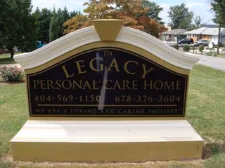 Front yard sign for Legacy Personal Care Home with contact numbers.