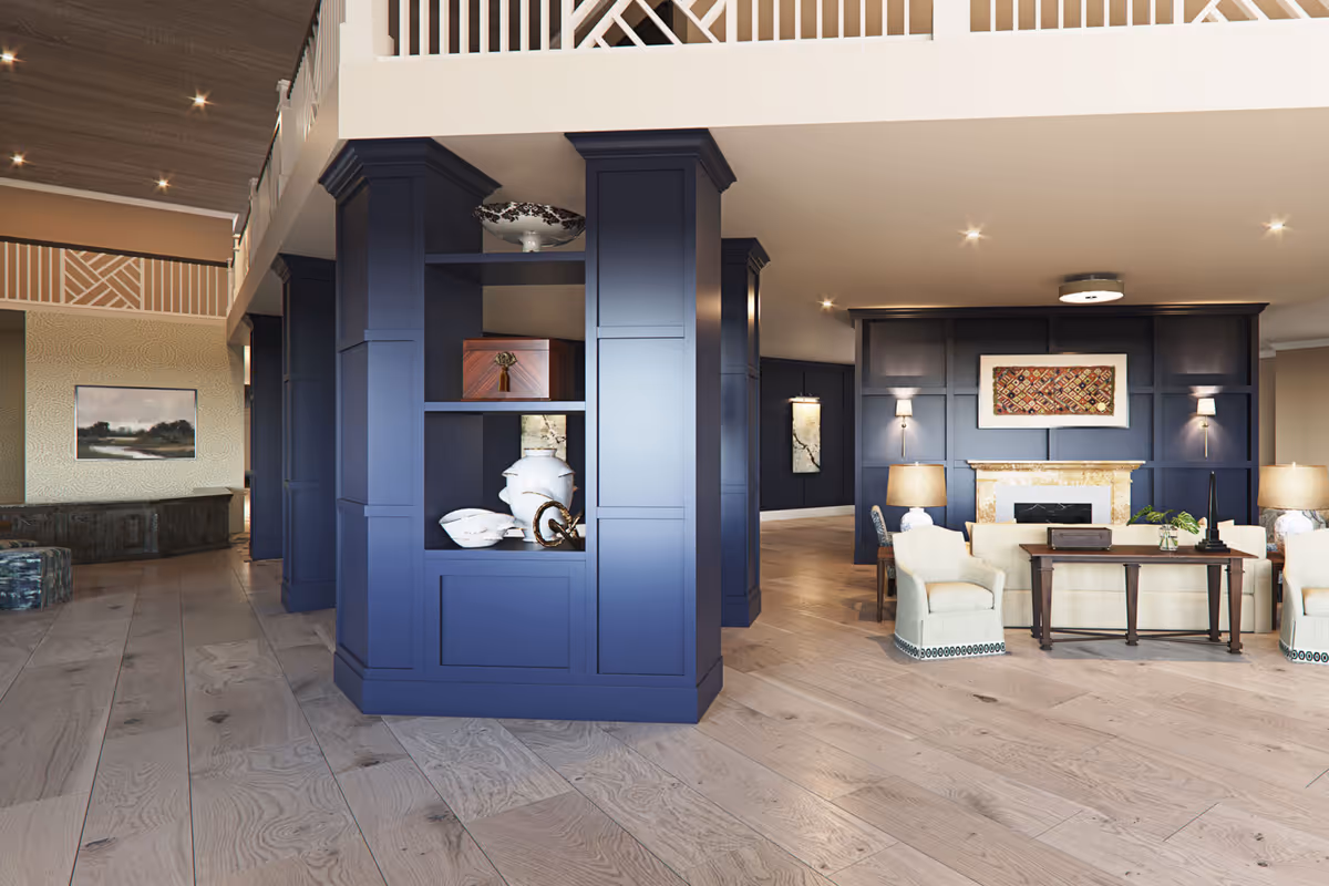 Spacious elegant lobby with navy blue built-in columns and shelving, a seating area around a fireplace, and light wood floors.