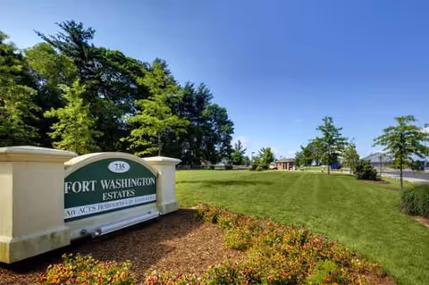 Exterior view of Fort Washington Estates entrance with manicured lawn and trees