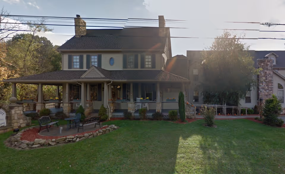 Exterior view of Carriage Manor, a senior living facility with a covered front porch.