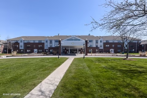 Front view of Towne Centre senior living facility with lawn and walkway.