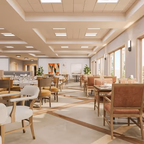 Bright, spacious dining room with multiple set tables and chairs, large windows, plants, and modern ceiling lighting.