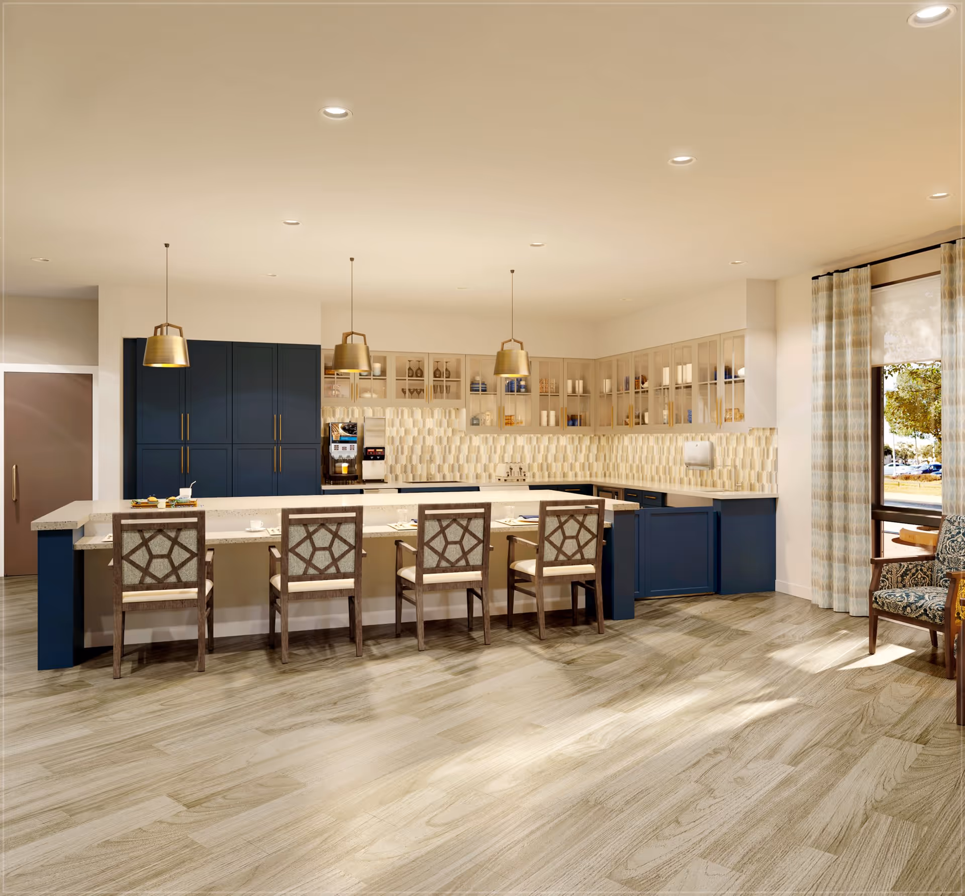 A modern kitchen area with a large island countertop surrounded by five wooden chairs with patterned cushions. The kitchen features dark blue lower cabinets and beige upper cabinets with glass doors. Three pendant lights hang above the island. The backsplash has a geometric tile design, and there is a coffee machine on the counter. Large windows with striped curtains allow natural light to brighten the space, and a wooden armchair with patterned upholstery is visible near the window.