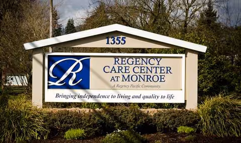Exterior sign for Regency Care Center at Monroe with landscaping in front yard.