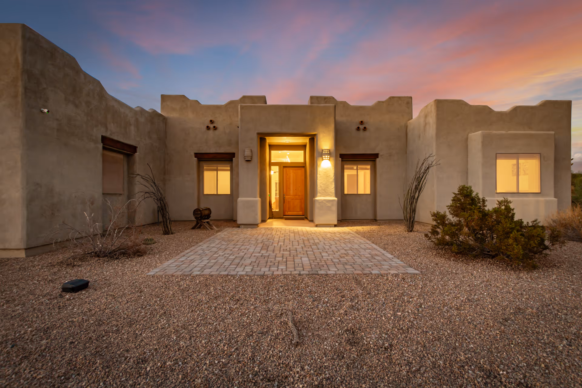 Front exterior of a desert-style senior living facility with a central entrance and walkway.