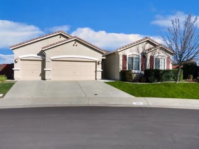 Exterior view of Elite Quality Care facility with attached garages and landscaped front yard.