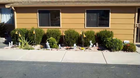 Exterior view of Westfield Assisted Living building with shrubs along the sidewalk.
