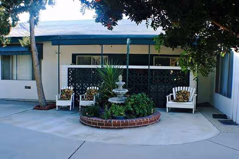 Outdoor courtyard seating area in front of a building, with a fountain.