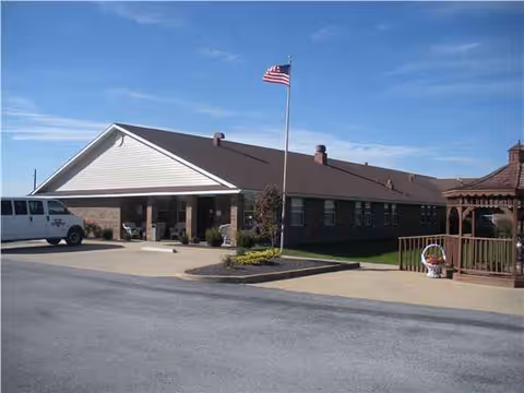 Exterior view of Glenwood Rehabilitation & Health Care Center with flag and driveway.