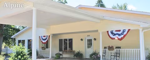 Front exterior of a single-story facility with a covered porch and patriotic bunting.