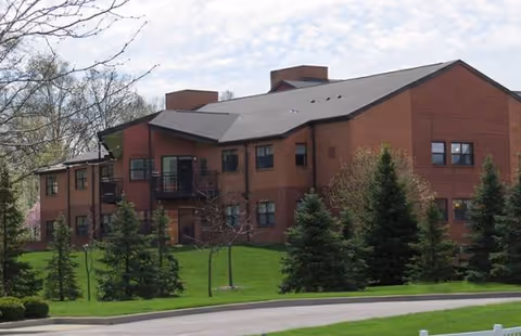 Exterior of Lutheran Village at Wolf Creek, a brick building with green lawn and trees.