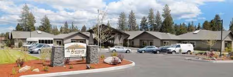 Exterior view of Mt. Bachelor Memory Care with parked cars and landscaped surroundings.